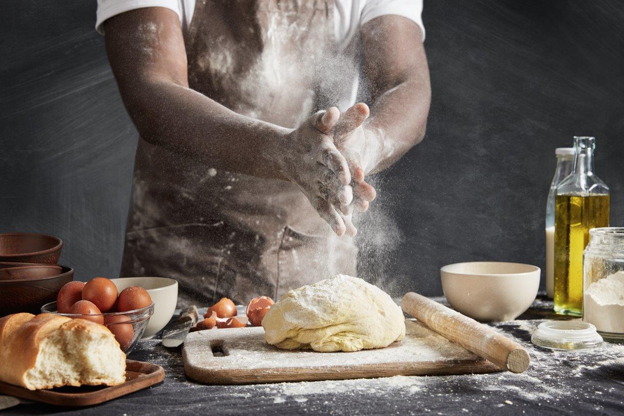 Chef claps floud-covered hand over dough