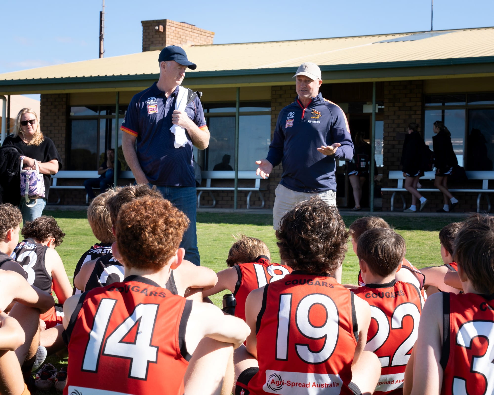 Crows past players, Peter Caven and Kym Koster speaking to players mid-game at the Eyre United Football Club at part of Bunge's Country connect programme