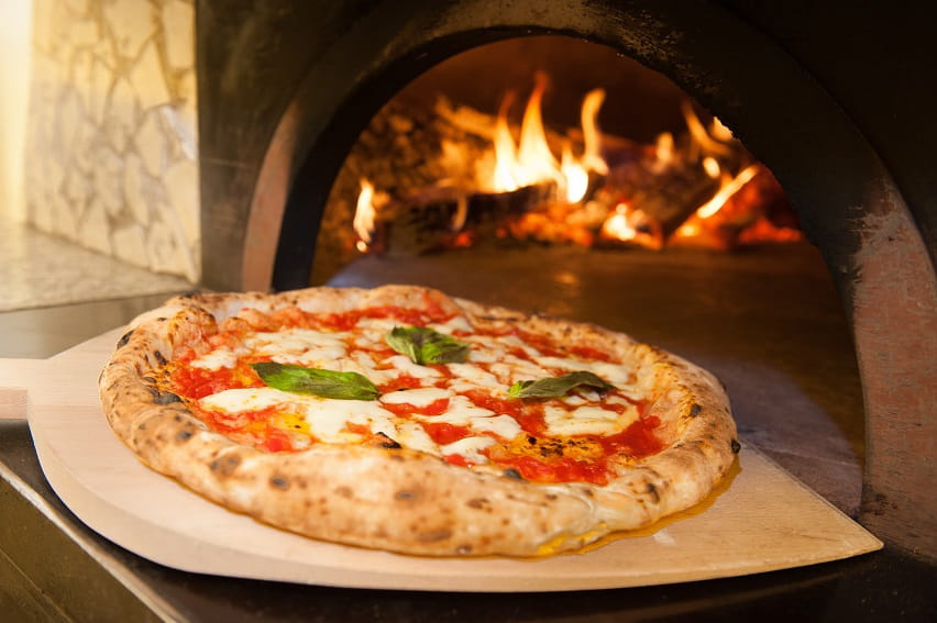 Pizza coming out of the oven